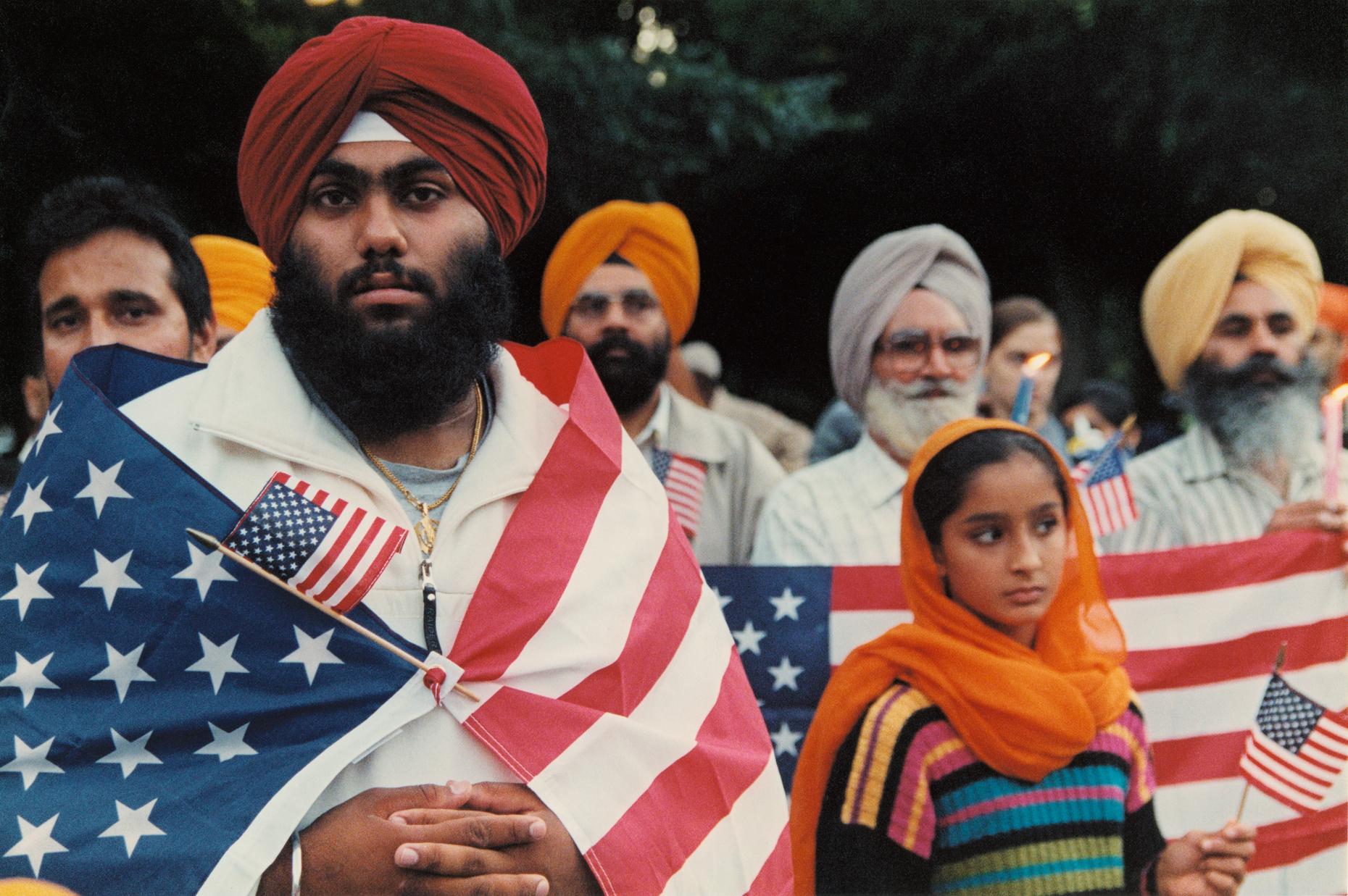 A Sikh man with a United States flag draped over his shoulders, taken shortly after 9/11.