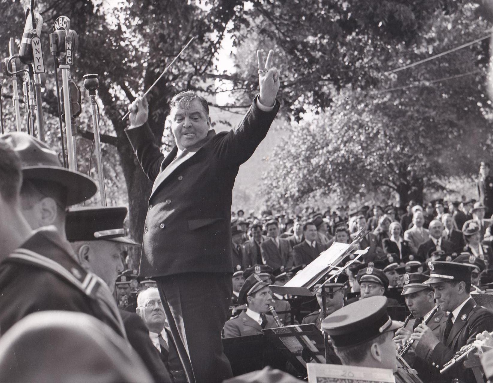 Mayor La Guardia conducts the combined police, fire and sanitation department bands in God Bless America for I Am An American Day in Central Park on May 22, 1942.